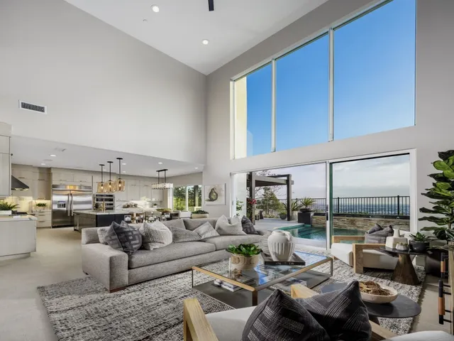 a living room with furniture kitchen view and large windows
