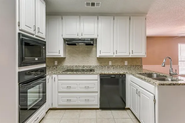 a kitchen with stainless steel appliances granite countertop a stove and a refrigerator