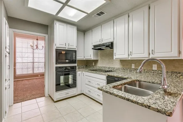 a kitchen with granite countertop a sink stainless steel appliances and cabinets