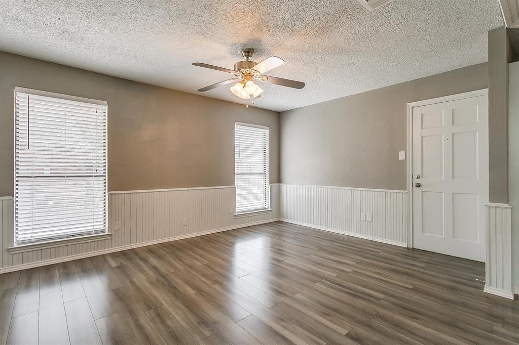 2407 Ridgevalley Drive McKinney, TX 75071 - Photo 16 of 28 an empty room with wooden floor chandelier fan and windows