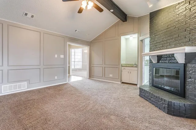 a view of empty room with cabinet and fan