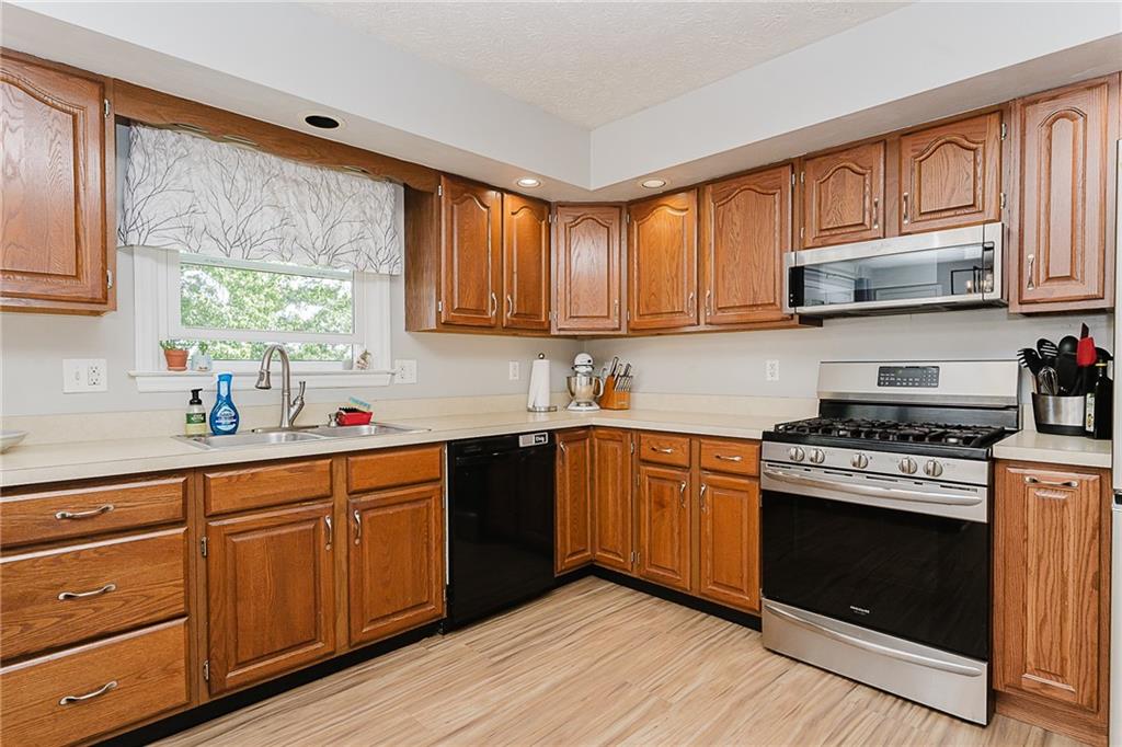 979 Barclay Road Indiana, PA 15701 - Photo 11 of 37 a kitchen with stainless steel appliances granite countertop wooden cabinets a sink a stove a refrigerator with grey cabinets and wooden floor