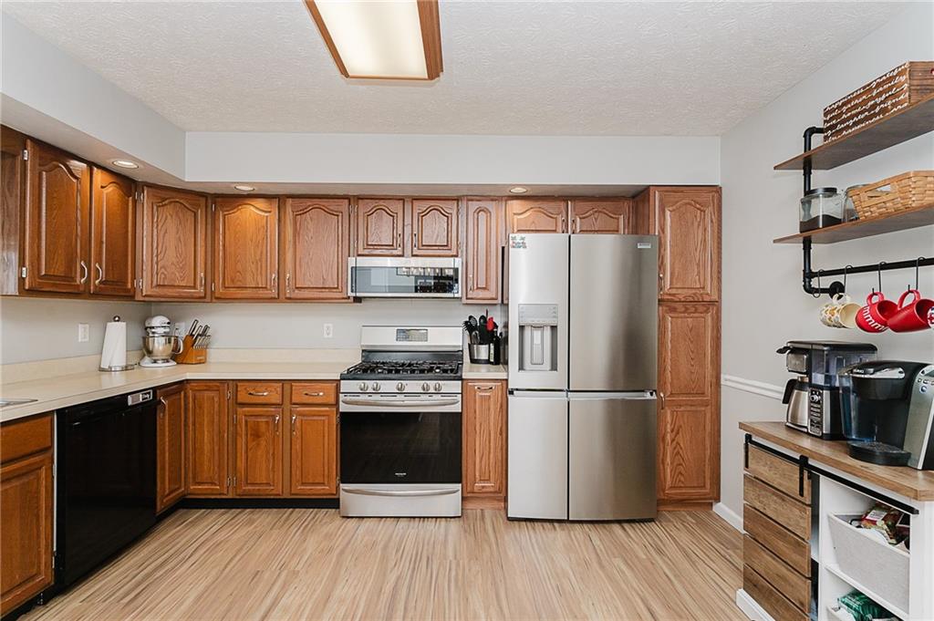 979 Barclay Road Indiana, PA 15701 - Photo 13 of 37 a kitchen with stainless steel appliances granite countertop a refrigerator stove top oven and wooden floors
