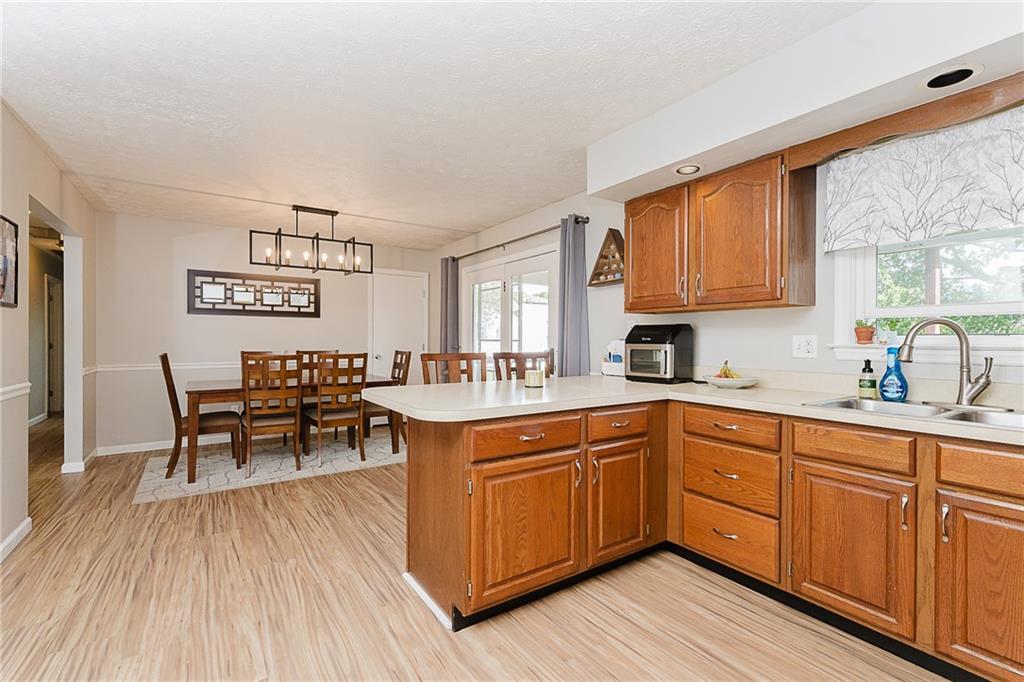 979 Barclay Road Indiana, PA 15701 - Photo 14 of 37 a kitchen with stainless steel appliances granite countertop wooden floors a stove top oven a sink with dining table and chairs