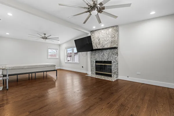 an empty room with windows fireplace and wooden floor