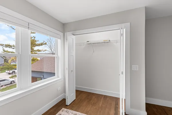 a view of a small space with wooden floor and a window