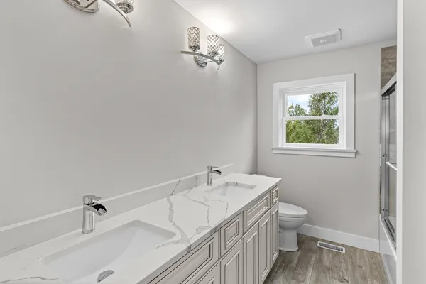 a bathroom with a sink a toilet and shower