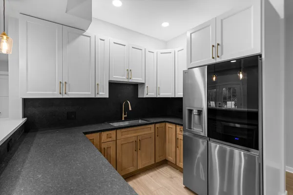 a kitchen with kitchen island granite countertop a sink a stove and refrigerator