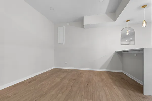 a view of a room with wooden floor and white walls