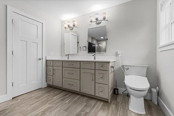 a bathroom with a toilet a sink and mirror