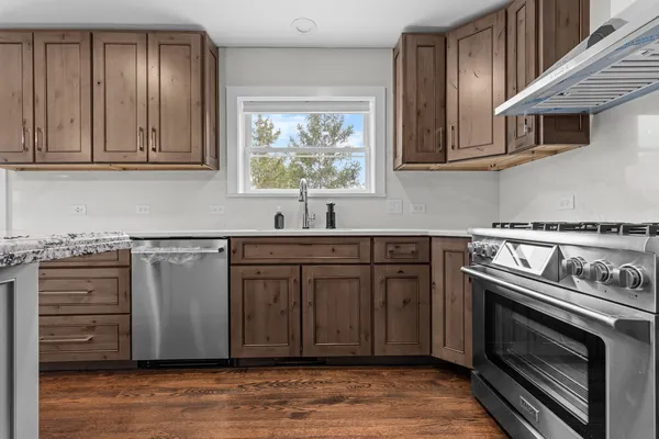 a kitchen with stainless steel appliances granite countertop a stove a sink and a microwave