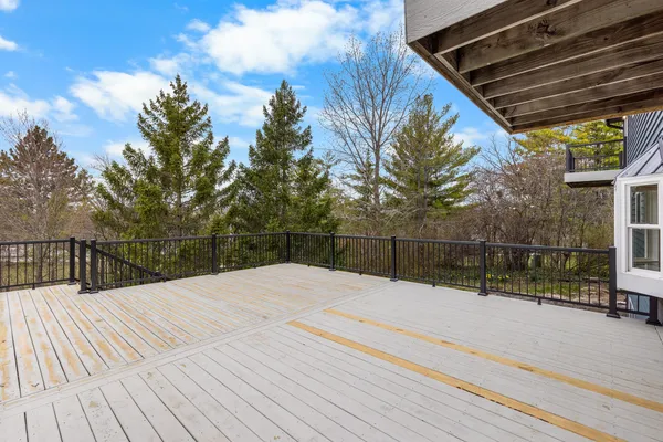 a view of backyard with wooden fence and large trees