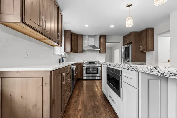 a kitchen with stainless steel appliances granite countertop a stove top oven a sink and dishwasher