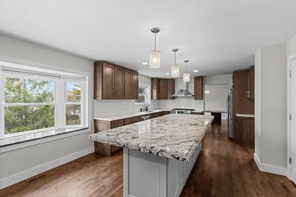 a kitchen with kitchen island a stove and a wooden floor