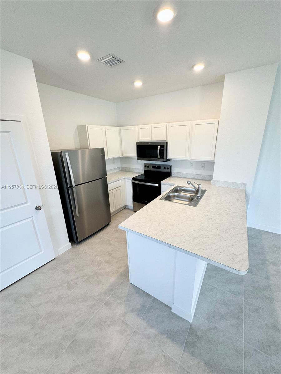 891 Northwest 3rd Street, Unit 891 Pompano Beach, FL 33060 - Photo 16 of 33 a kitchen with sink cabinets and refrigerator