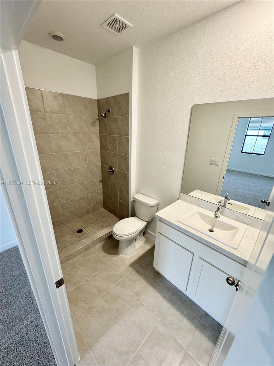 891 Northwest 3rd Street, Unit 891 Pompano Beach, FL 33060 - Photo 22 of 33 a bathroom with a double vanity sink toilet and shower
