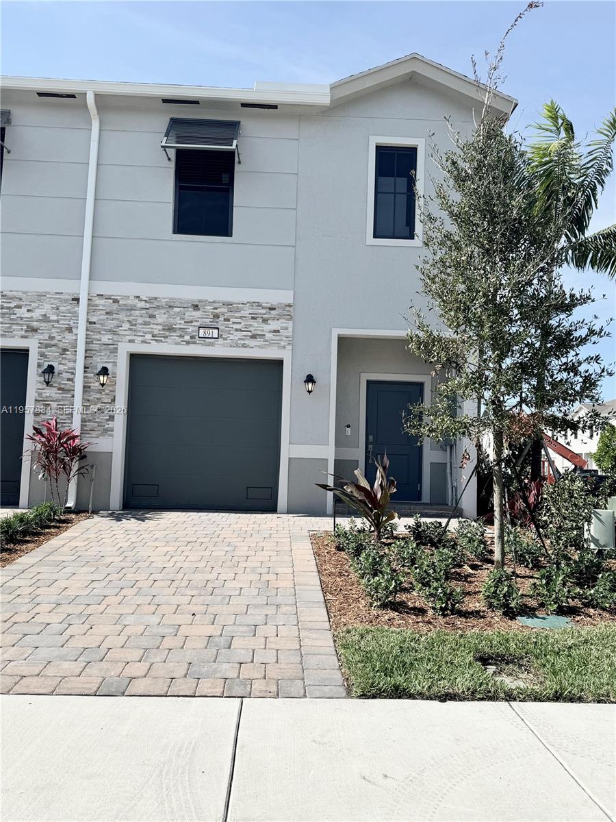 891 Northwest 3rd Street, Unit 891 Pompano Beach, FL 33060 - Photo 3 of 33 a front view of a house with a yard and garage