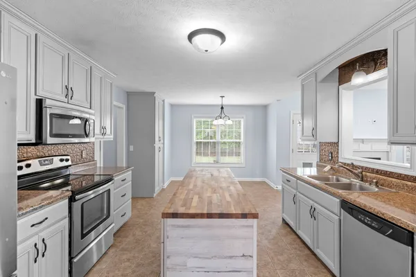 a kitchen with stainless steel appliances granite countertop a stove and a sink