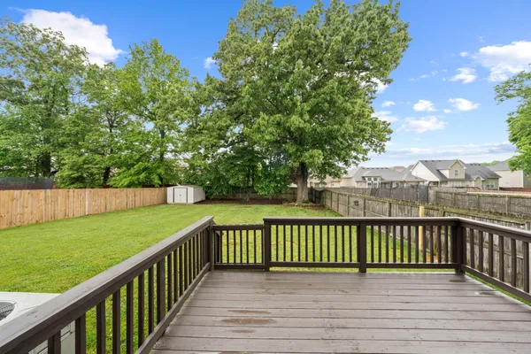 a view of a roof deck with wooden fence and floor