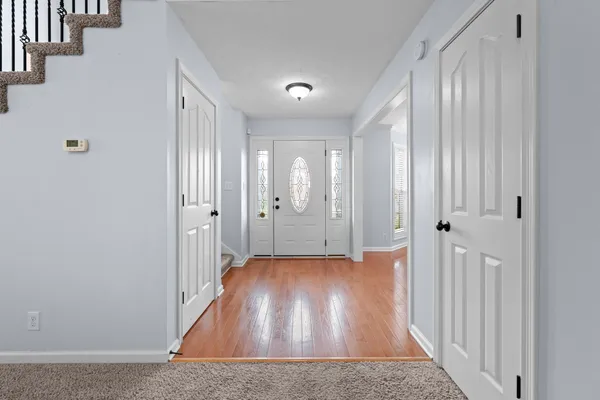 a view of a hallway with wooden floor and staircase