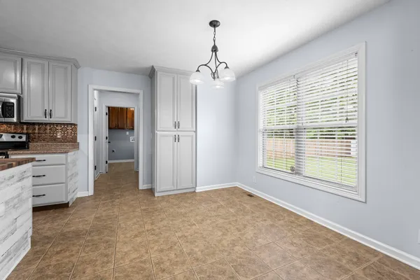 a view of an empty room with window and cabinet