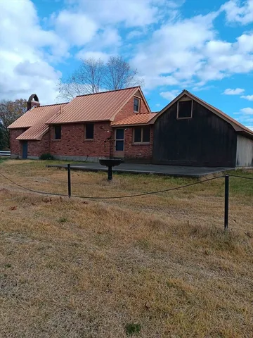 a backyard of a house with table and chairs