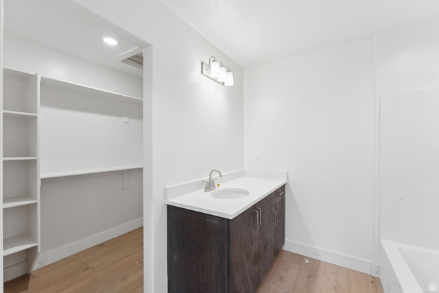 1617 North Angel Street Layton, UT 84041 - Photo 30 of 43 Bathroom with vanity, light wood-style floors, a tub to relax in, a spacious closet, and recessed lighting