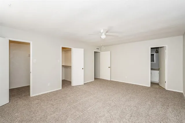 a view of an empty room with a ceiling fan