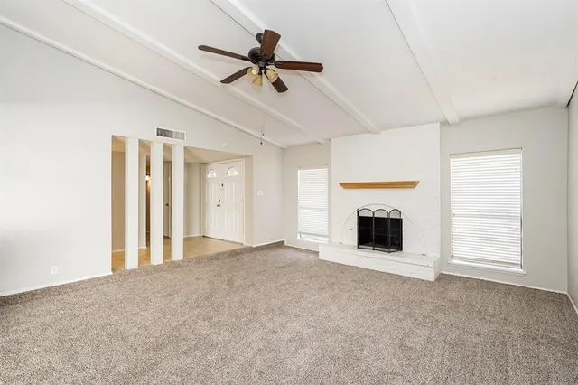 a view of an empty room with a fireplace and a window