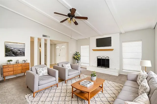 a living room with furniture a fireplace and a flat screen tv