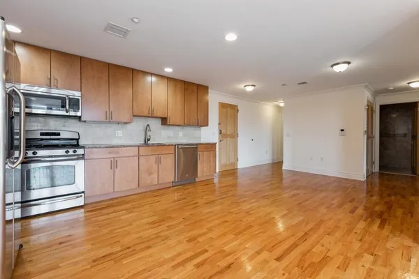 a kitchen with stainless steel appliances granite countertop a stove a sink and a refrigerator