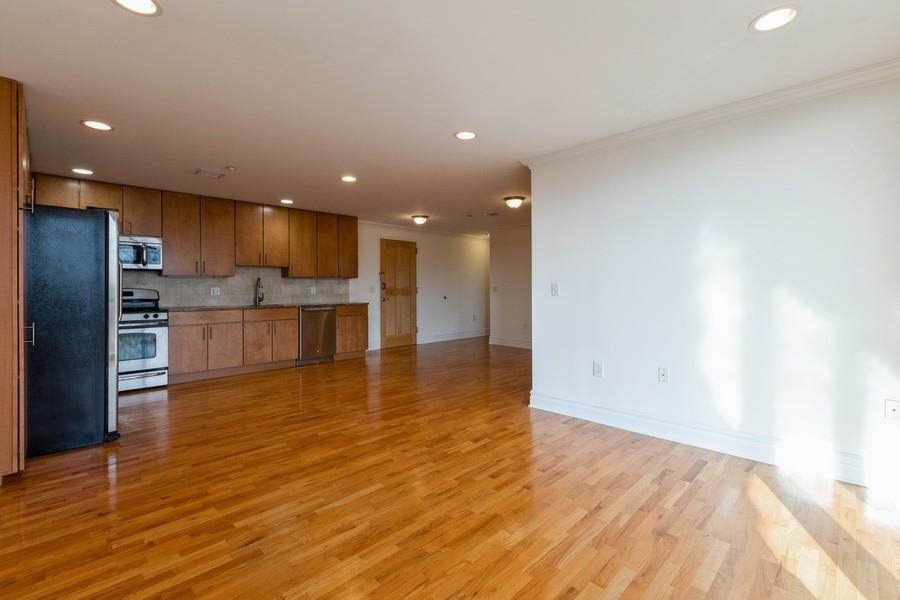17 Meadow Road, Unit 407 Rutherford, NJ 07070 - Photo 7 of 21 a view of kitchen dining space with stainless steel appliances wooden floor and a large window
