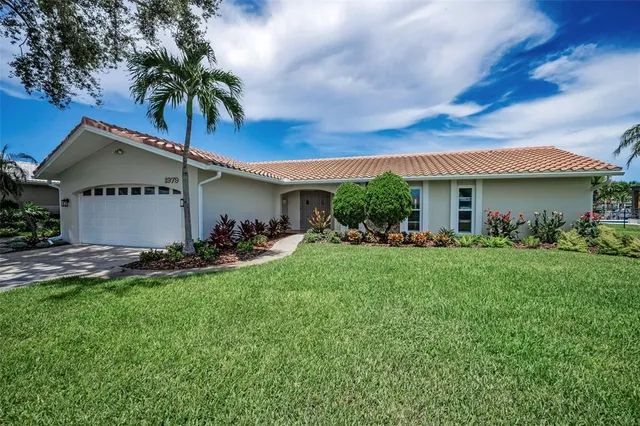 a front view of a house with a garden and plants