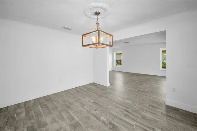a view of a room with wooden floor and white walls