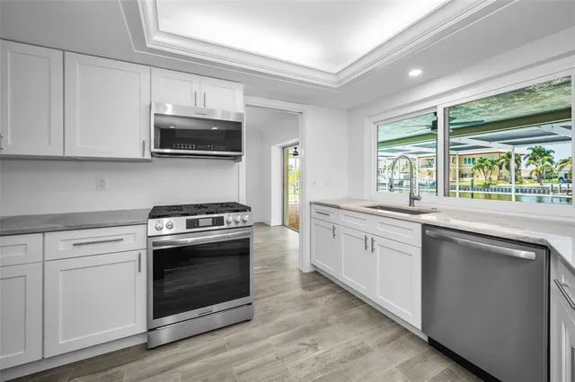 a kitchen with stainless steel appliances white cabinets and a stove top oven