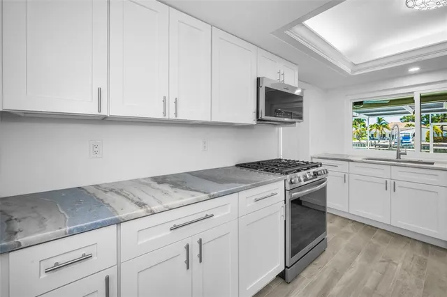 a kitchen with granite countertop cabinets stainless steel appliances and sink