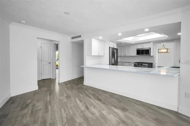 a view of kitchen with granite countertop cabinets and refrigerator