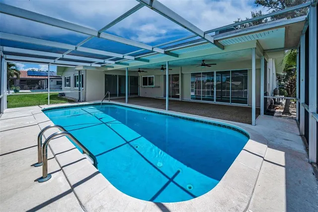 a view of a house with a swimming pool and sitting area