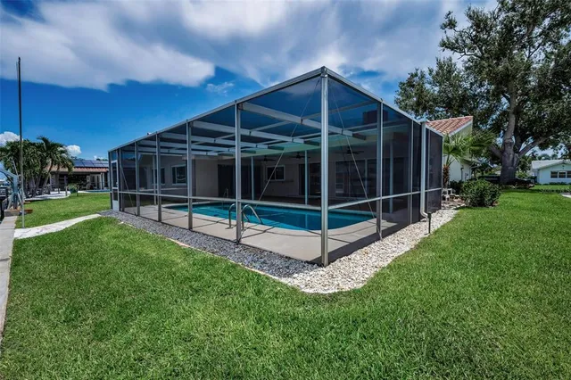 a view of a backyard with wooden fence and a large tree