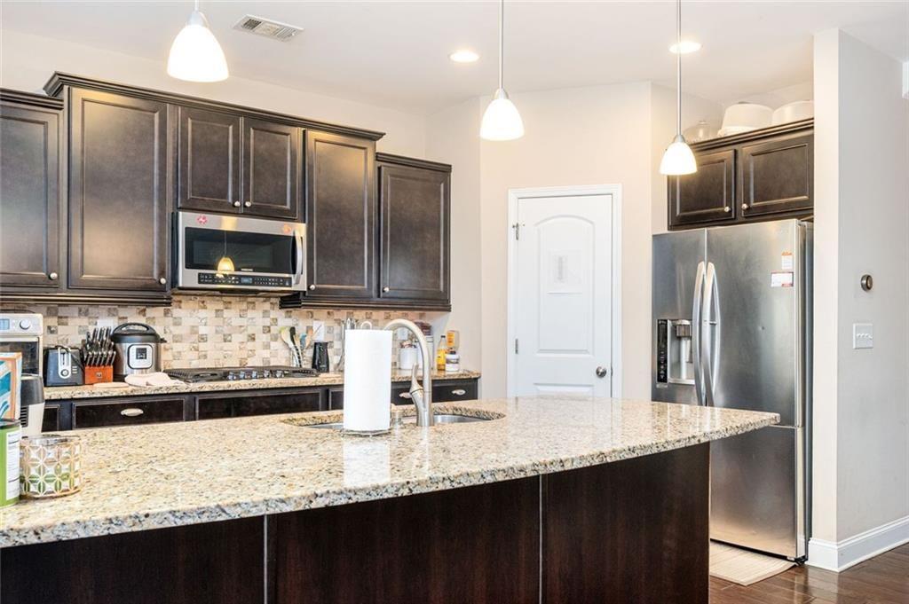 2020 Youngstown Place Powder Springs, GA 30127 - Photo 13 of 25 a kitchen with granite countertop stainless steel appliances and wooden cabinets