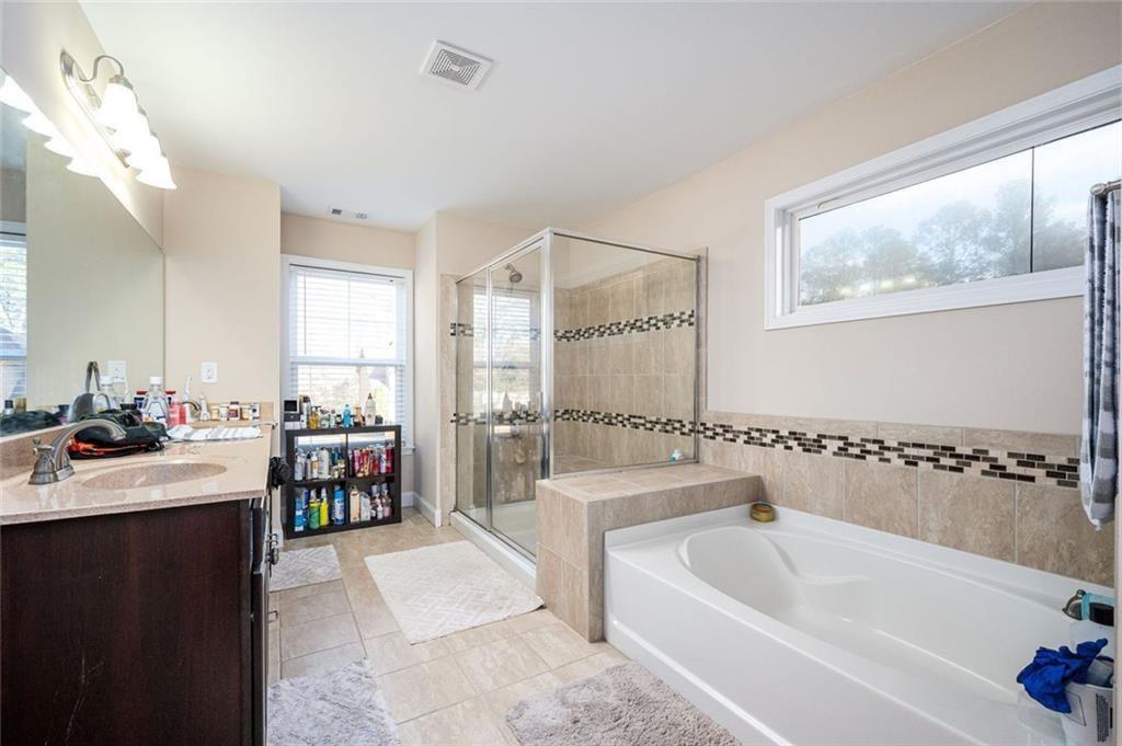 2020 Youngstown Place Powder Springs, GA 30127 - Photo 17 of 25 a bathroom with a tub a sink and mirror