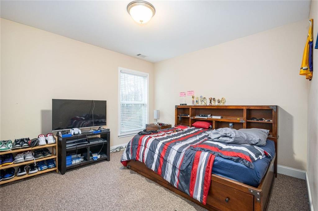 2020 Youngstown Place Powder Springs, GA 30127 - Photo 18 of 25 a bedroom with a bed and a flat screen tv
