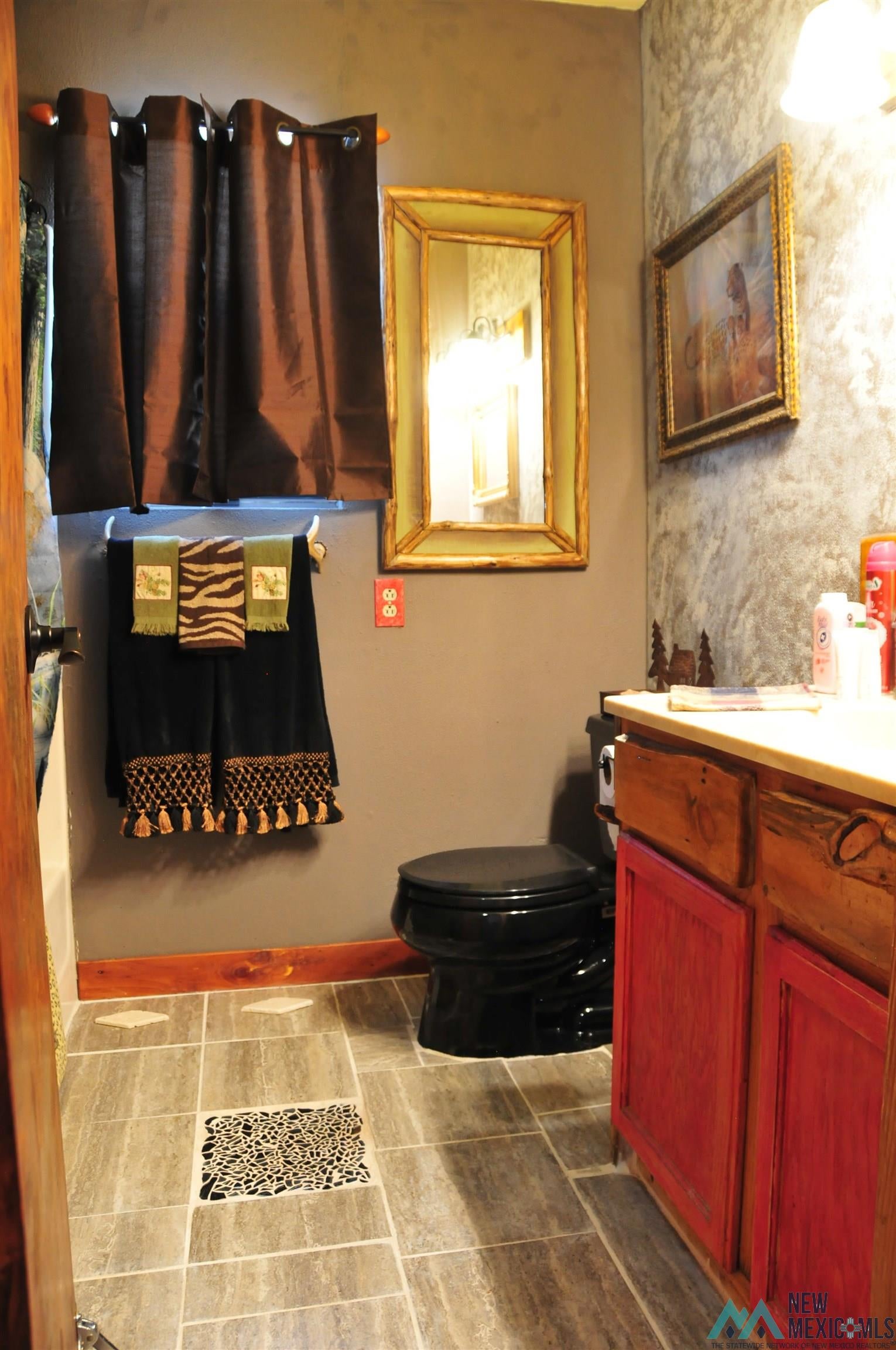 25 Bluff Road Thoreau, NM 87323 - Photo 26 of 31 Bathroom featuring a black commode, wood-finish vanity with red cabinet doors, light-toned countertop, and a framed mirror
