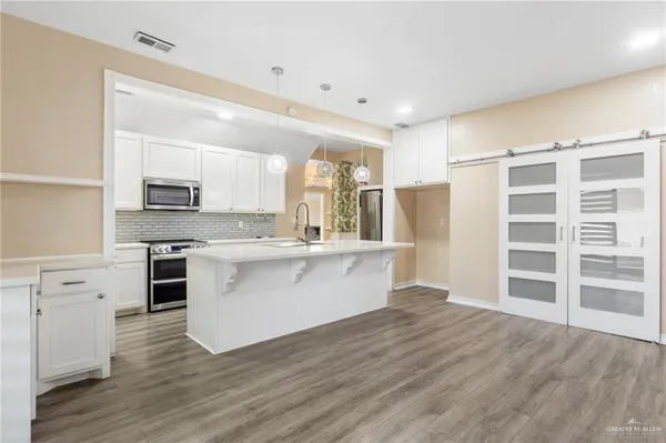 a large kitchen with a center island and stainless steel appliances