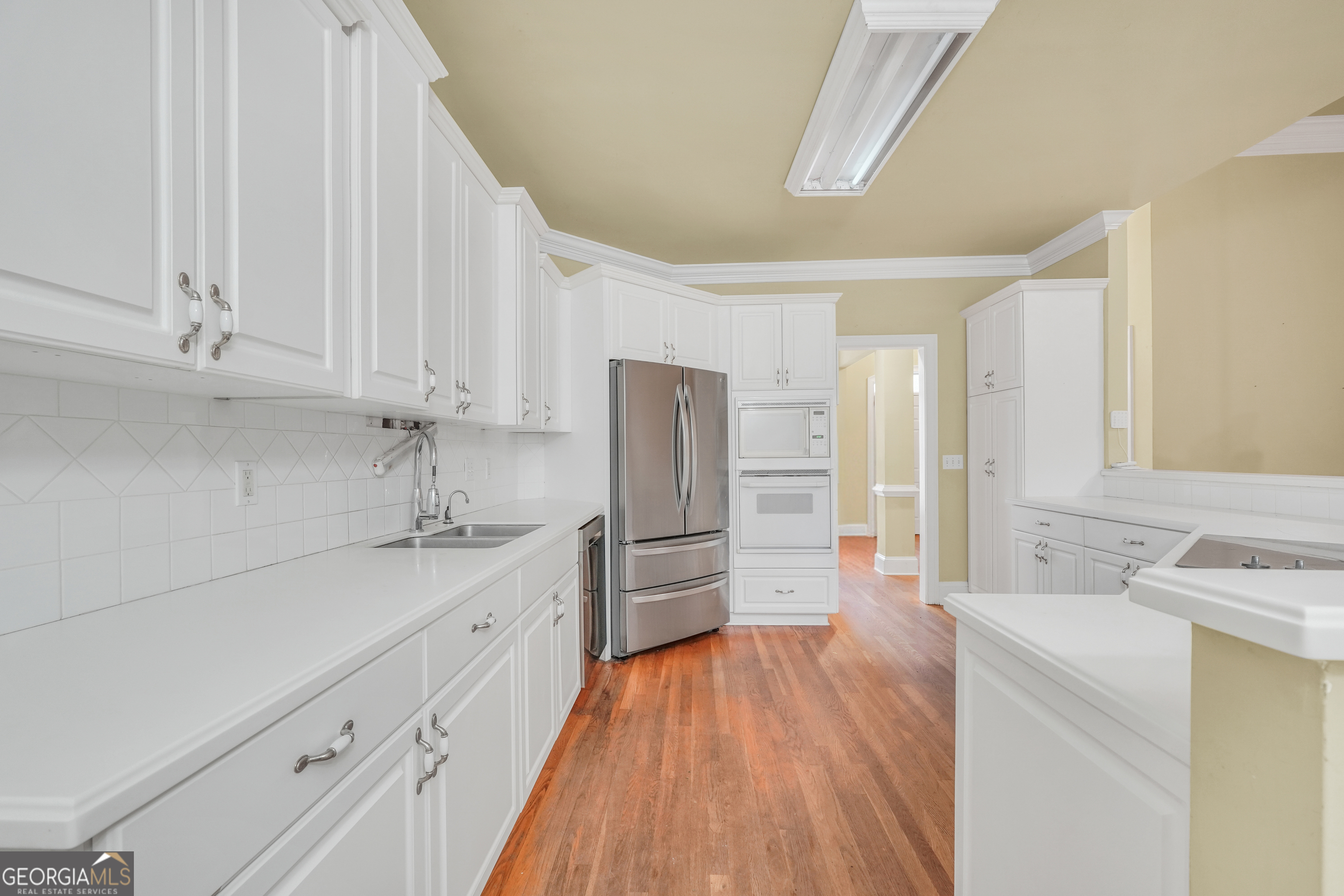 3003 Southwest East Fairview Road McDonough, GA 30252 - Photo 11 of 48 a kitchen with a sink a refrigerator and wooden floor