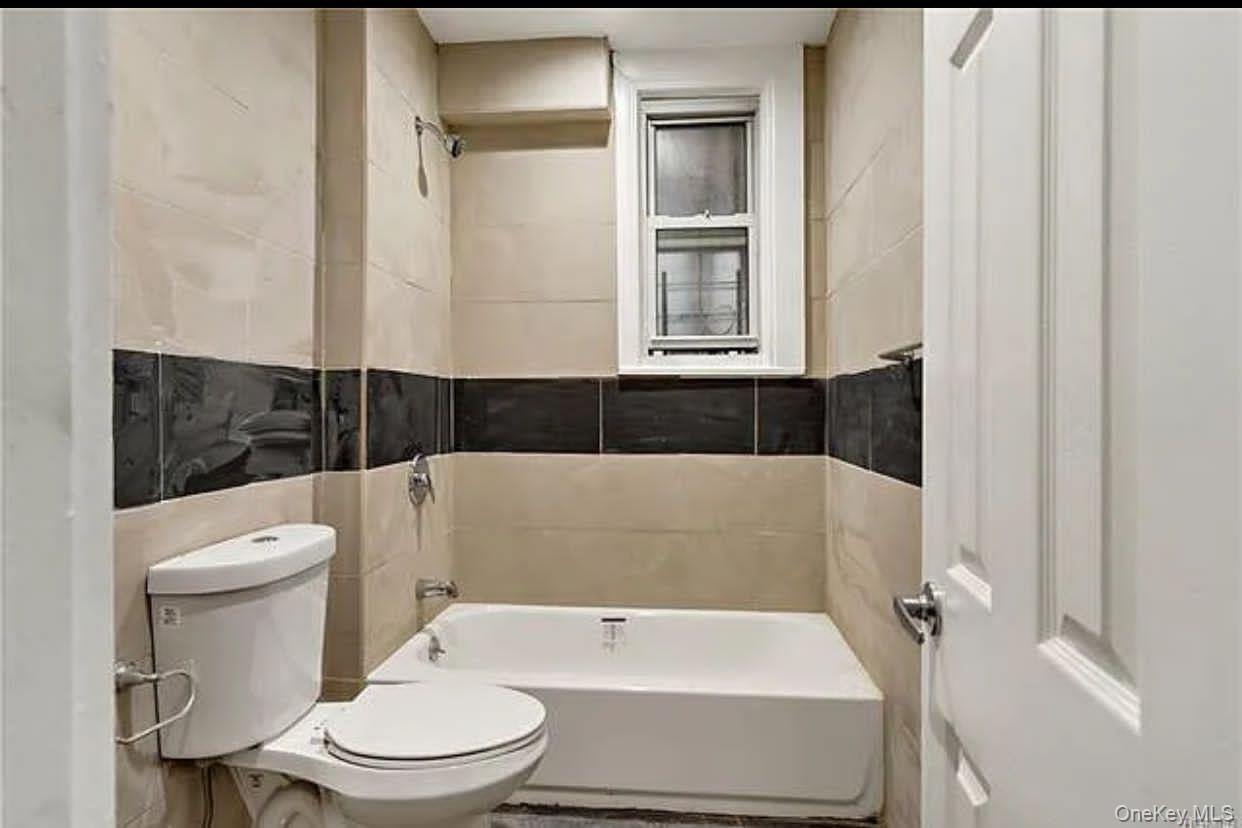 1350 Clay Avenue Bronx, NY 10456 - Photo 3 of 4 Full bathroom featuring bathtub / shower combination and tile walls