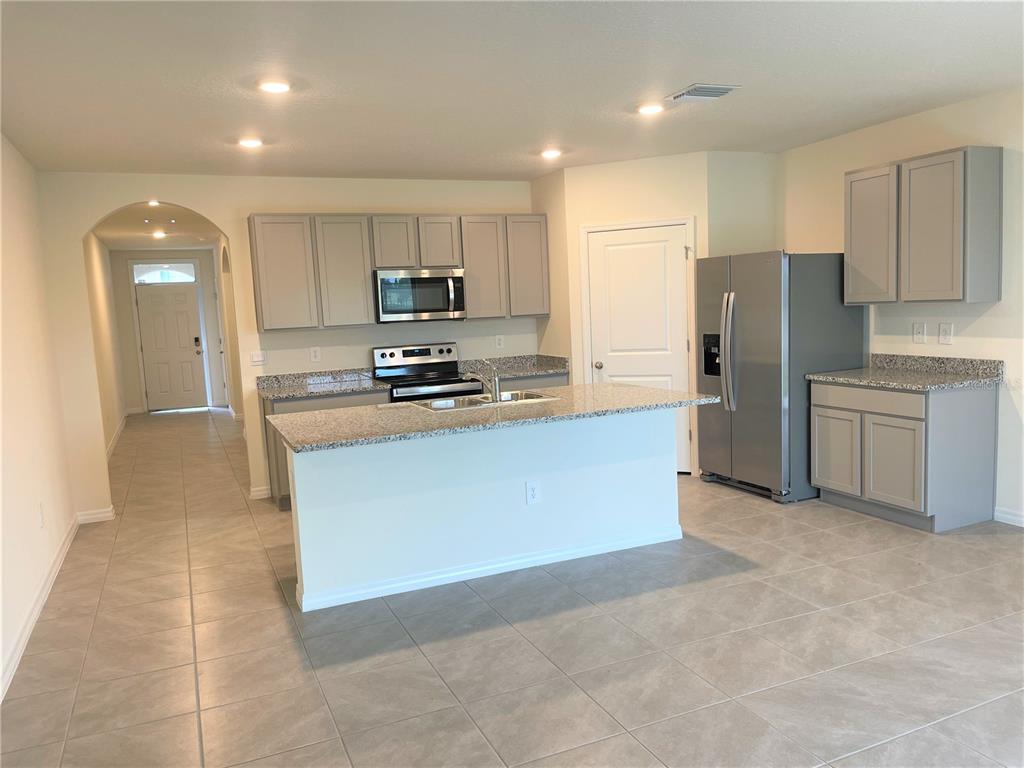 5105 Sultana Cove Bradenton, FL 34211 - Photo 6 of 23 a kitchen with stainless steel appliances a refrigerator a stove a sink a washer and cabinets