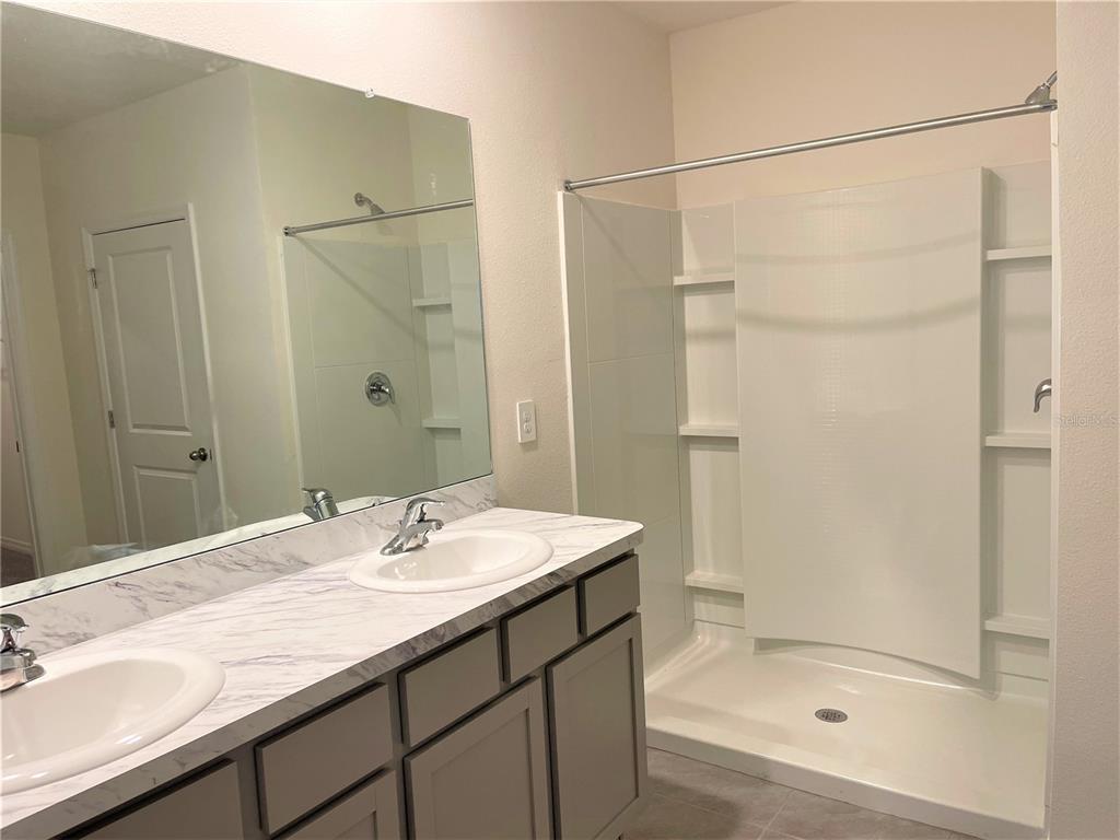 5105 Sultana Cove Bradenton, FL 34211 - Photo 10 of 23 a bathroom with a shower sink vanity and mirror
