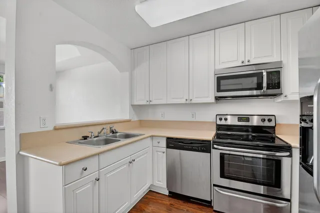 a kitchen with granite countertop cabinets stainless steel appliances and wooden cabinets