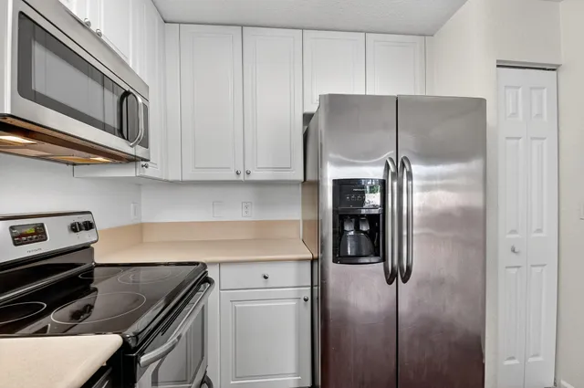 a kitchen with stainless steel appliances granite countertop a refrigerator and a stove top oven